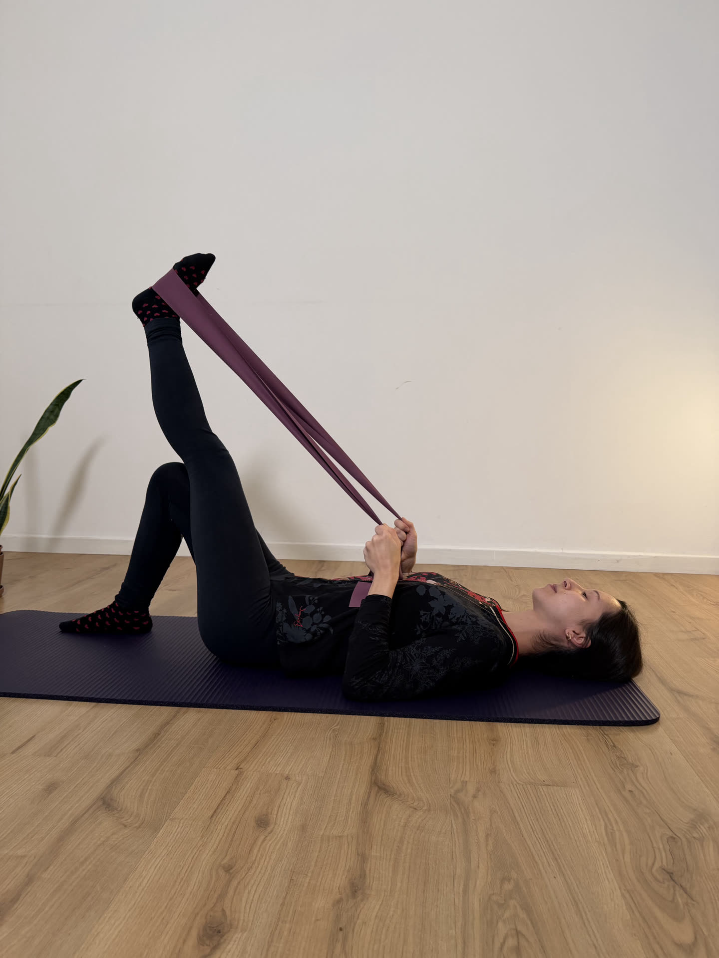 Insegnante durante un esercizio di Pilates Matwork con l'elastico, sdraiata sul tappetino in sala a Mompiano